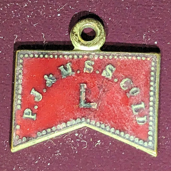 Rectangle pass with triangle indent bottom and ring on top. Pass is brass with red enamel. Company name in an arc above the letter "L"