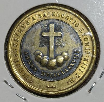 Reverse of the round medallion: reverse with a Latin cross, rays between the arms, clouds at the base, inscribed below ‘ANNUS MDCCCLXXXVIII’ (Year 1888), circumscribed ‘QUINQUAGESIMUS SACERDOTIO LEONIS XIII P•M•’ (Fifty (years) of priesthood Leo XIII Pope);