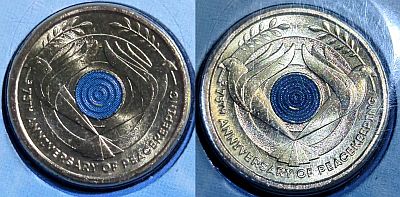 Two views of the reverse of the coin in different light. Two Peace Doves with Olive branch either side of a central blue circle Script: Latin Lettering: C AS 75TH ANNIVERSARY OF PEACEKEEPING Designer: Aleksandra Stokic Read more on Wikipedia