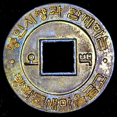 Brass plated coin with a square central hole. Korean characters / 오백 (Tonging City Market, Five hundred)