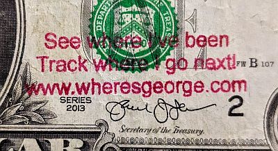 Detail of the note showing the Department of treasury seal with ONE printed over the top, the series 2013 identification, signature of the secretary of the treasury and stamp: See where I've been Track where I go next! www.wheresgeorge.com