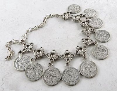 10 coins each attached by one side around 2/3 of a bracelet. Coin bracelet from https://www.etsy.com/au/listing/1011909921/coin-bracelet-in-silver-tone-faux?ga_order=most_relevant&ga_search_type=all&ga_view_type=gallery&ga_search_query=coin+bracelet&ref=sr_gallery-1-10&organic_search_click=1