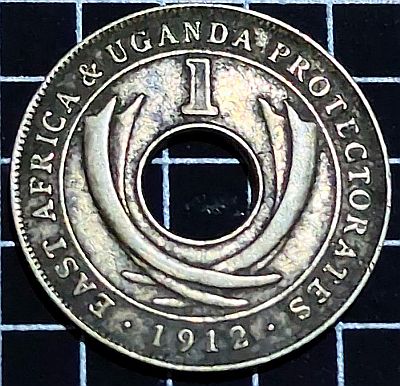 Curved tusks flank the centre hole Script: Latin Lettering: EAST AFRICA & UGANDA PROTECTORATES 1 .1912.