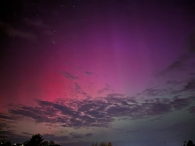 Photo of the Aurora on the evening of May 11th 2024, showing lots of red and pink in the sky with a little green as well