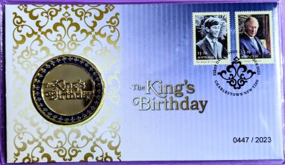 Blue gradient PNC with gold decoration on the left. Medallion left and two stamps with cancellation mark right. Title "The King's Birthday" centre