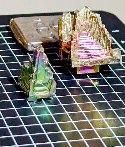 Two bismuth crystals in front of the ingot