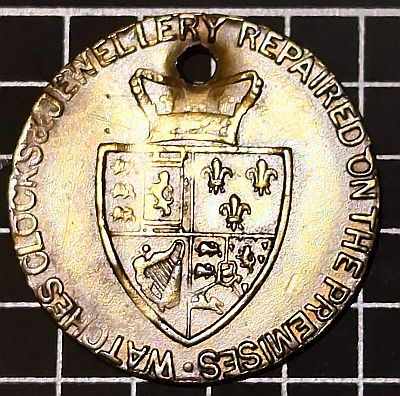 WATCHES, CLOCKS & JEWELLERY REPAIRED ON THE PREMISES. / Image of spade shaped coat of arms