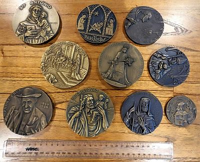 Group of 10 large brass medals on table, with 30cm ruler (bottom) for size.